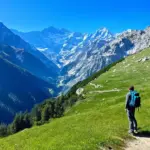 Scenic view of the Swiss Alps with a backpacker admiring the landscape.