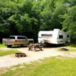 A travel trailer being backed into a campsite.