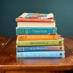 Stack of colorful Bill Bryson travel books on a wooden table.