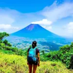 Woman hiking with a view of Volcano Atitlan in Guatemala