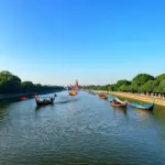 Scenic view of the Perfume River in Hue with traditional boats and lush greenery.