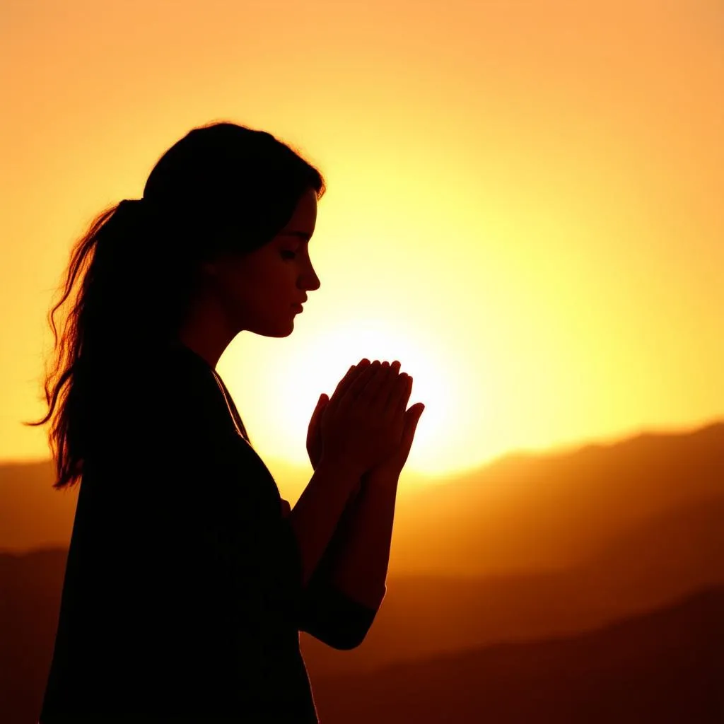 Woman Praying at Sunset