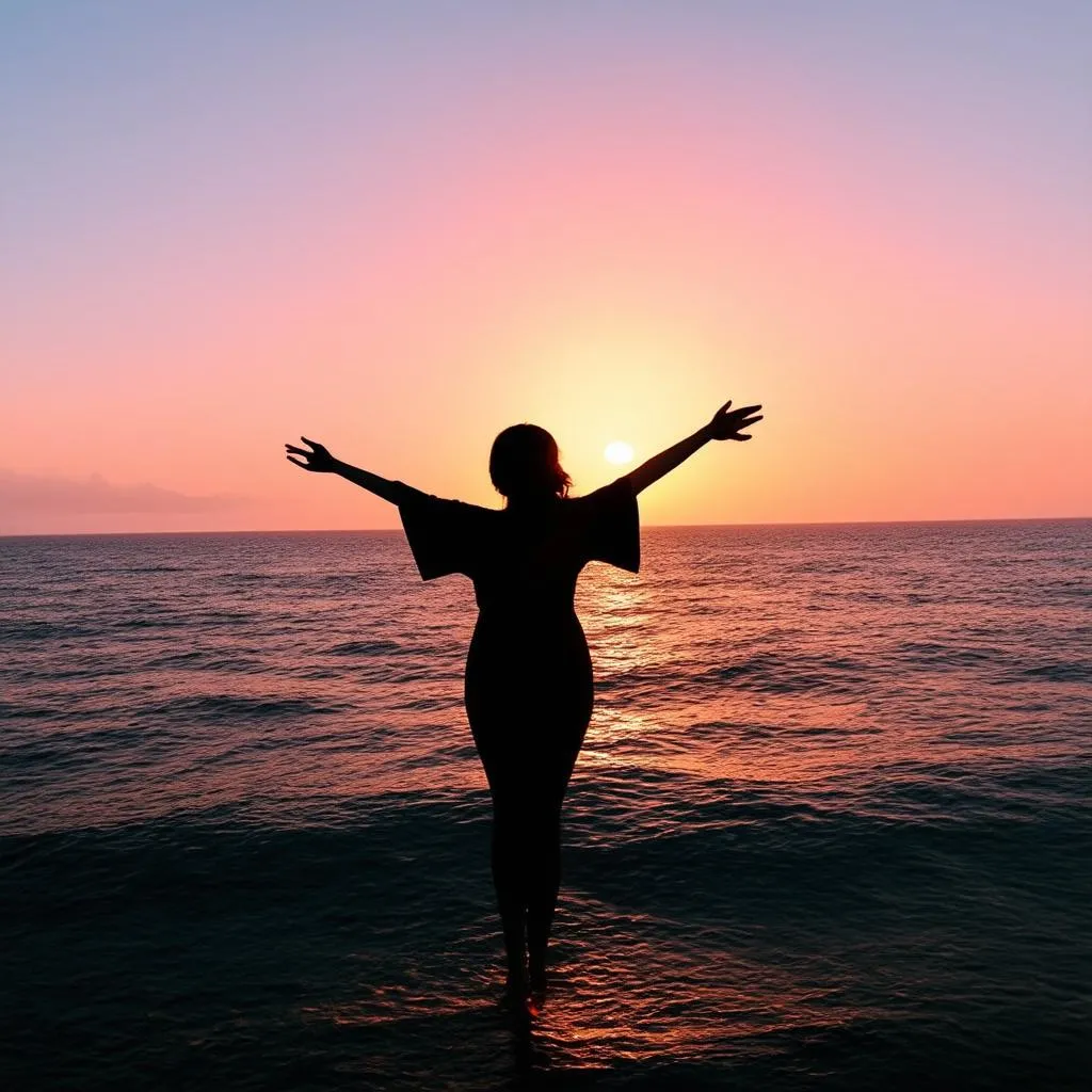 Woman standing on a cliff overlooking the ocean at sunset