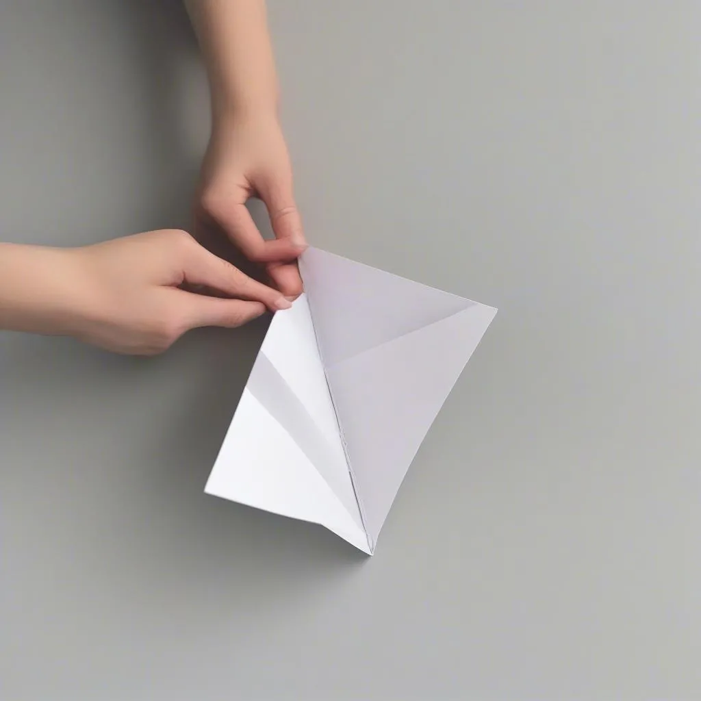 Folding a piece of paper in half to create a triangle