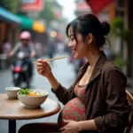 Pregnant woman enjoying a bowl of pho in Hanoi