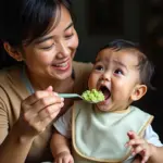 Vietnamese mom feeding baby pureed green vegetables