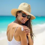 Woman Applying Sunscreen at the Beach