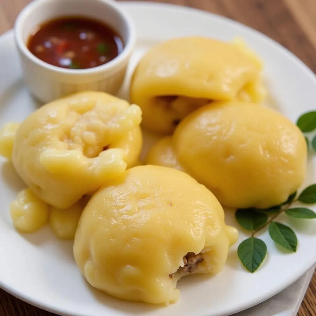 A plate of Banh Nam, steamed corn cakes, served with dipping sauce in Hanoi