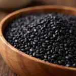 Black sesame seeds in a wooden bowl