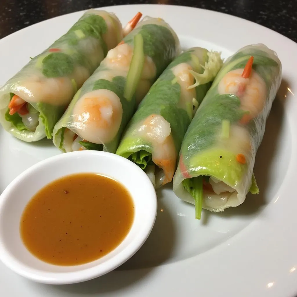 A plate of Goi Cuon spring rolls with dipping sauce