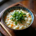 Steaming bowl of Vietnamese rice porridge with herbs