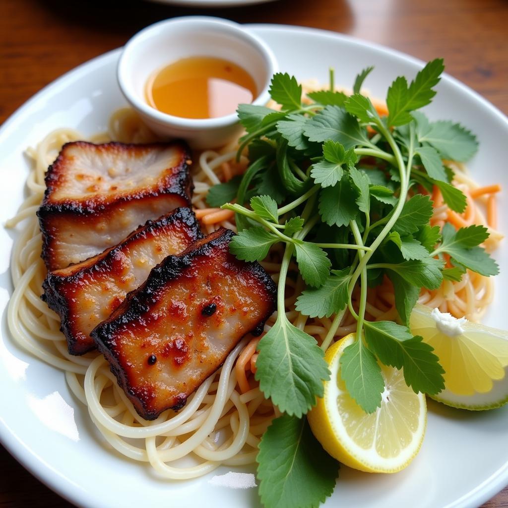 Hanoi meat dishes: A close-up shot of a plate of Bún chả, featuring grilled pork, vermicelli noodles, herbs, and dipping sauce.