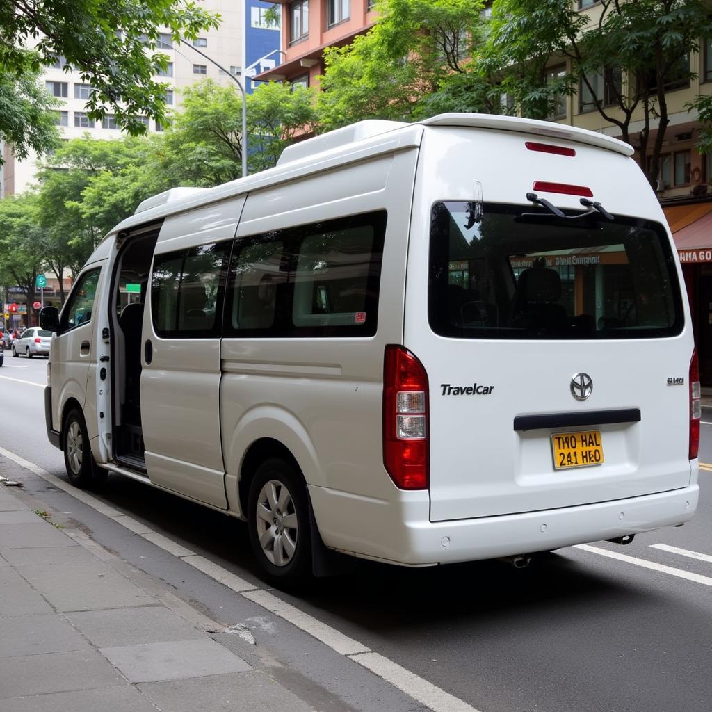 TRAVELCAR's 16-seater van parked on a Hanoi street.