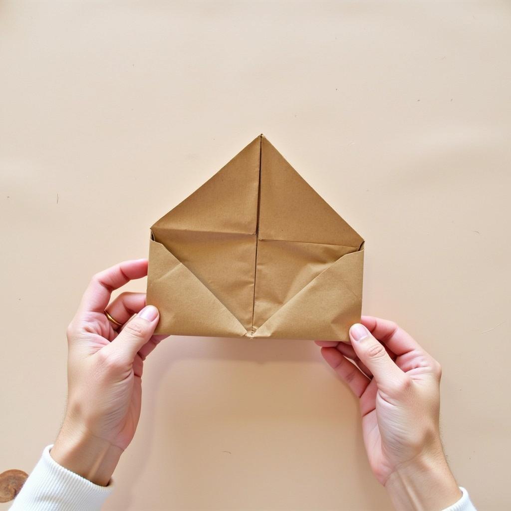 Creating a triangular fold on a paper bag